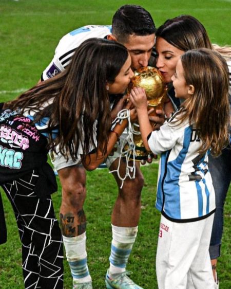 jorgelina cardoso along with her husband angel di maria and two daughter mia di maria and pia di maria kissing the fifa 2022 world cup trophy